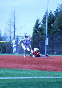 softball fielder tagging sliding baserunner at base