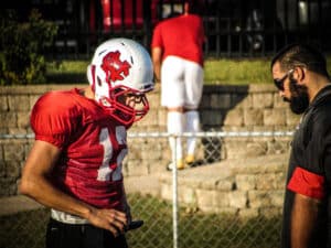 football coach working with quarterback to use gorout device