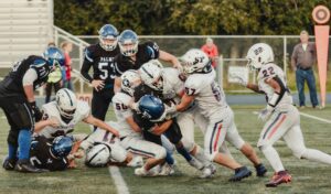 american football defensive players tackling runner