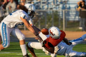 football player fumbling after getting tackled