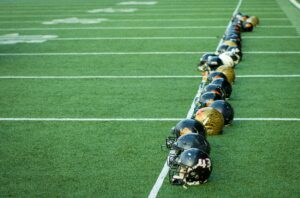 football helmets lined up on field