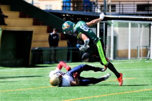football player stepping over defender