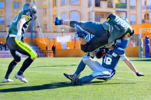 football player tackling sliding quarterback